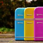 Three small fridges in blue, yellow and pink