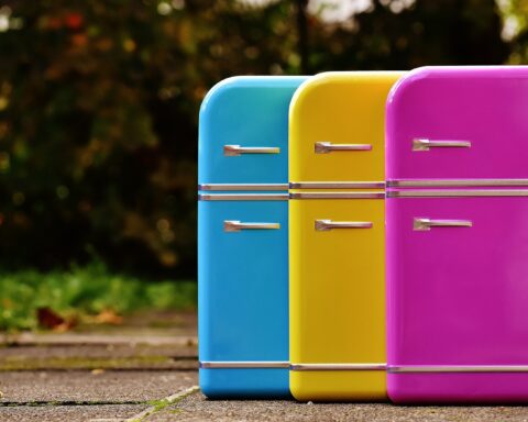 Three small fridges in blue, yellow and pink